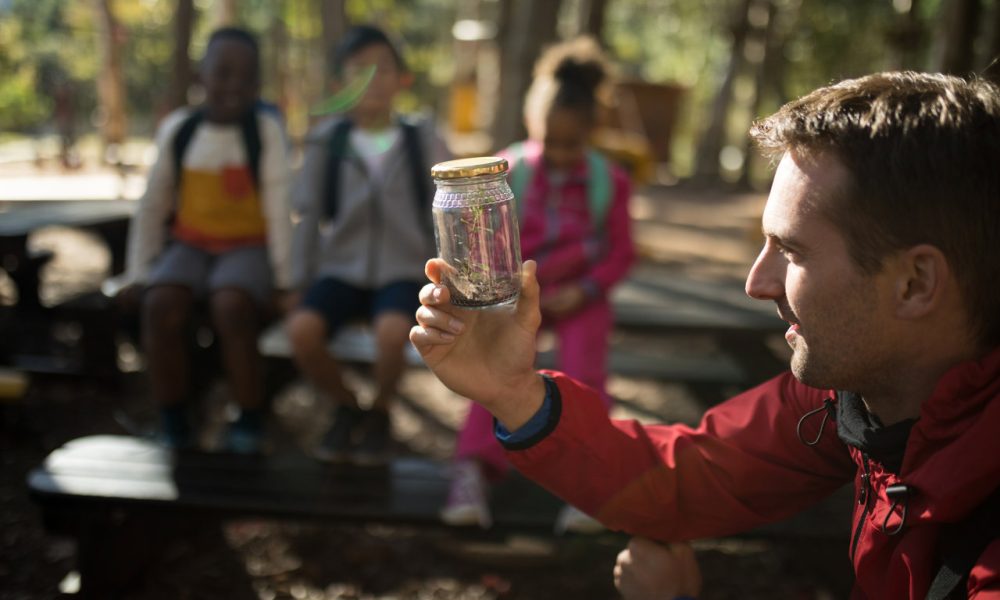 Teacher experimenting soil in park on a sunny day